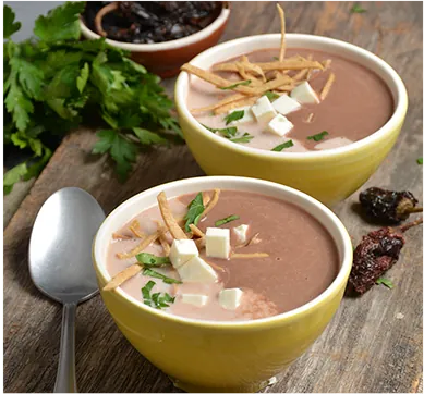 Creamy bean soup topped with cheese and tortilla strips