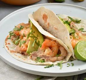 Shrimp tacos with refried beans and avocado